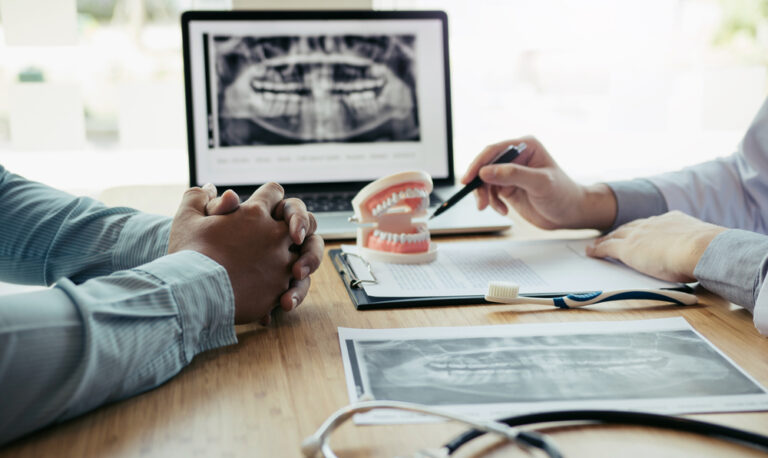 Dentist and patient discussing dental problems at report x-ray image