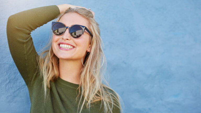 Stylish young woman in sunglasses smiling